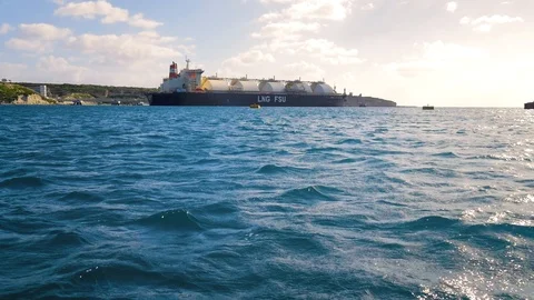 Flying over the water with views of the ship, seaport and green relief land. Sea Stock Footage 101828785