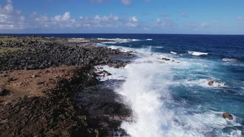 Flying over waves crashing on rocks in Aruba Stock Footage 235475129
