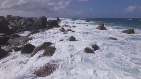 Flying over waves crashing on rocks in Aruba Stock Footage 235476177