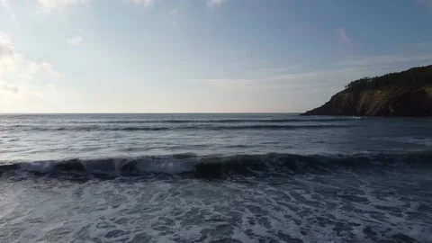 Flying over waves into the sea in Playa de Cueva, Asturias, Spain 4K Video stock 155588229