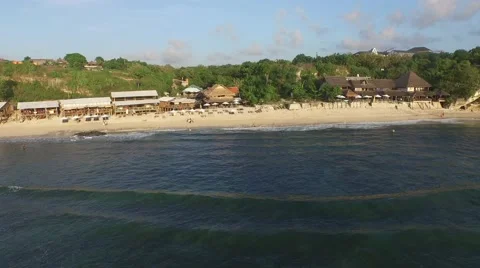 Flying over the waves to the seaside restaurants in Bali, Indonesia Stock Footage 61952048