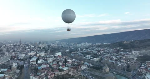 Flying over white balloon in the center of city. Sunset cityscape of Tbilisi Stock-Footage 174816342