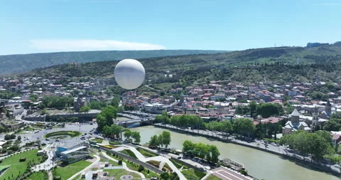 Flying over white balloon in the center of city. Morning cityscape of Tbilisi Stock-Footage 199019511