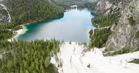 Flying over white Beach and Pine trees towards Lake Braies in South Tirol Video stock 148534978