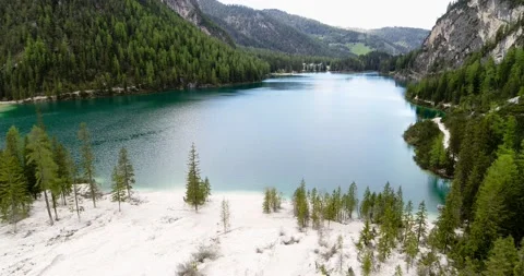 Flying over white Beach and Pine trees towards Lake Braies in South Tirol Stock Footage 148535522