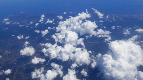 Flying over white fluffy clouds with a beautiful view of rural landscape Stock Footage 93176426
