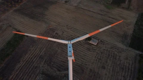 Flying over a wind turbine at sunset -view of the blades turning Video stock 159072182