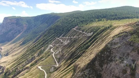 Flying over a winding mountain road on a high slope. Stock Footage 277191060