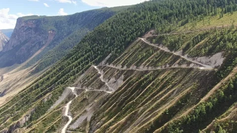 Flying over a winding mountain road on a high slope. Stock Footage 277191076