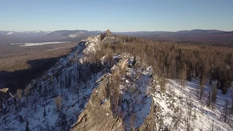 Flying over winter mountain ridge and forest to the big snow mountain Stock Footage 84178602