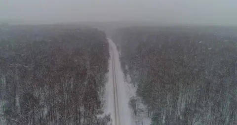 Flying over the winter road, with active snowfall Stock Footage 147678412