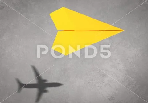 Photograph: Flying paper plane and shadow of a real airplane on grey ...