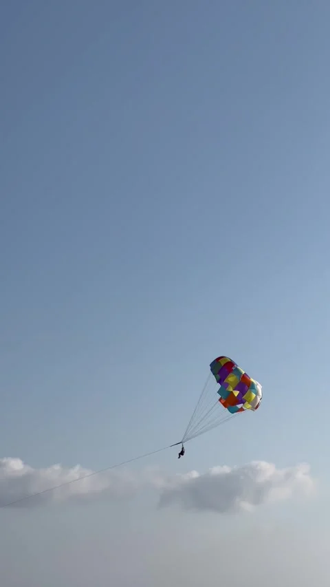Flying on a parachute behind a boat on a summer holiday by the sea Stock Footage 337134945