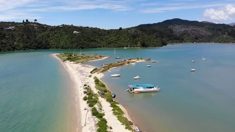 Flying parallel above a beach and yachts in summer at Marahau, New Zealand Video stock 100689360