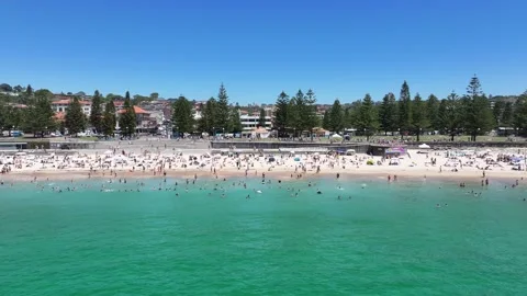 Flying parallel and away from famous Coogee Beach, with many people sunbathing Stock Footage 329067722