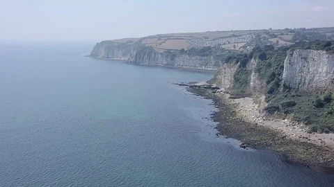 Flying parallel to white chalk cliffs of Seaton beach in east Devon, England. Stock Footage 92772049