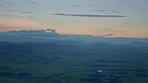 Flying past green fields and colourful sky at dusk Stock Footage 155445012