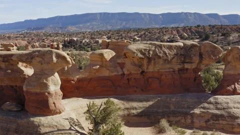 Flying past large rock formations in Devil's Garden Utah, revealing other rocks Stock Footage 248558454