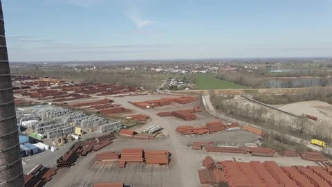 Flying past old smoke stack overlooking large industrial junk yard Vídeo Stock 150817734