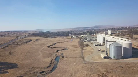 Flying past a silo complex in rural Africa with village and bush fire in BG Video stock 79806237