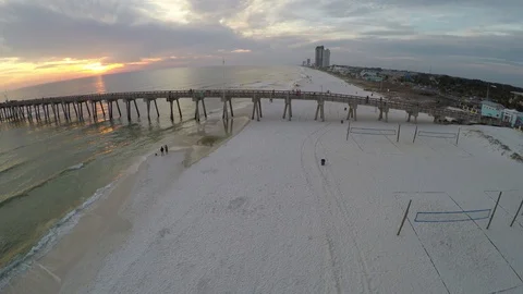 Flying perpendicular to and then over a pier down the beach. Stock Footage 90563177