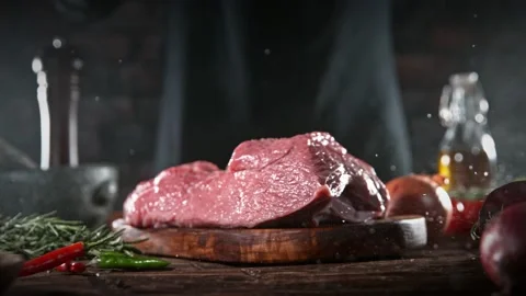 Flying piece of raw beef steak falling on table Stock Footage 169671064