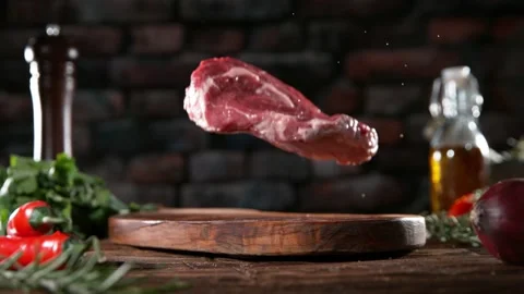 Flying piece of raw beef steak falling on cutting board. Stock Footage 169671480