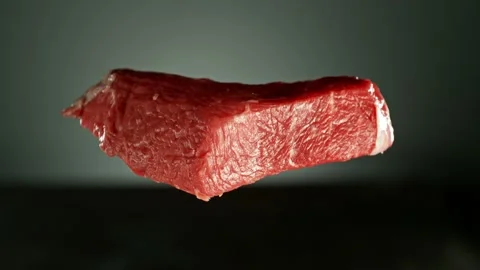 Flying pieces of raw beef steaks falling on table Stock Footage 237316326