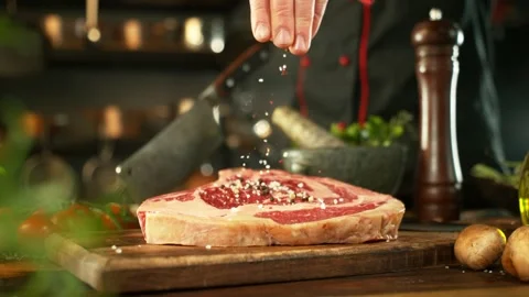Flying pieces spice on raw beef steak. Stock Footage 273576761