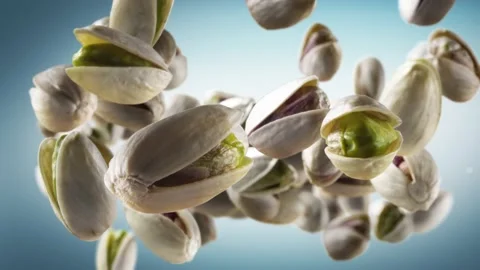 Flying of Pistachios in Cyan Background Stock Footage 147483067