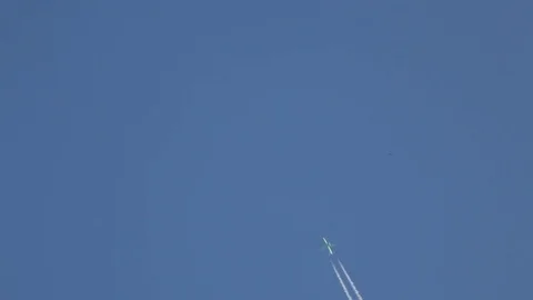 The flying plane against the background of the blue sky draws a double strip Stock Footage 78707951
