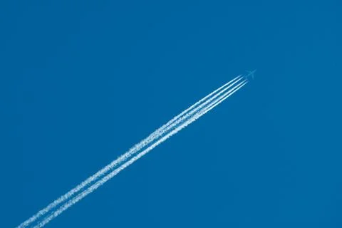 Flying plane and inversion trace from engines Stock Photos