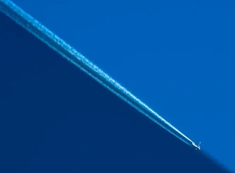 Flying plane in a cloudless sky Stock Photos