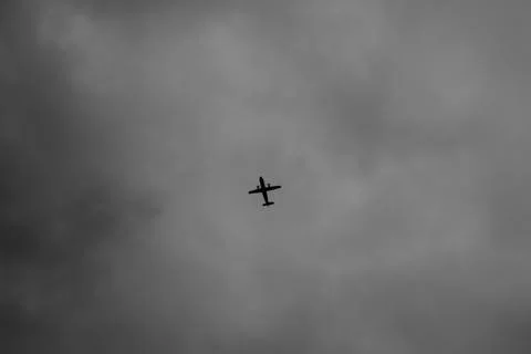 Flying plane in the cloudy sky Stock Photos
