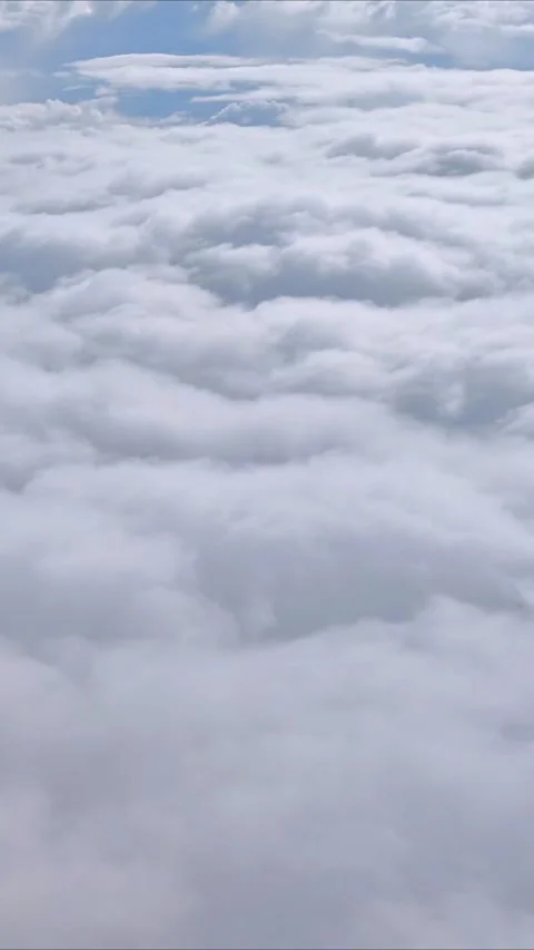 Flying in a plane through the fluffy, white clouds. Video stock 311991292