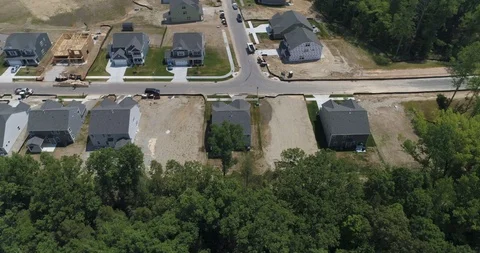 Flying by plot of land backed by forest in new estate of houses drone aerial 4k Stock Footage 114139841
