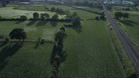 Flying from railway line with trees casting shadows, Drone, Yorkshire Stock Footage 95326504