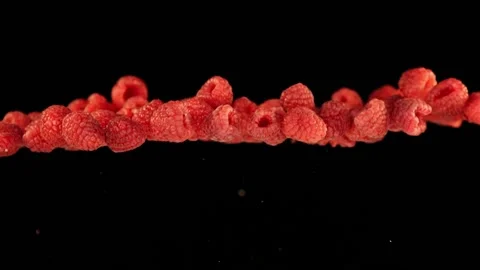 Flying raspberries infront of black background in slowmotion Stock Footage 163216295