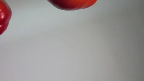 Flying red pepper and tomato colliding mid-air in slow motion Stock Footage 241250778