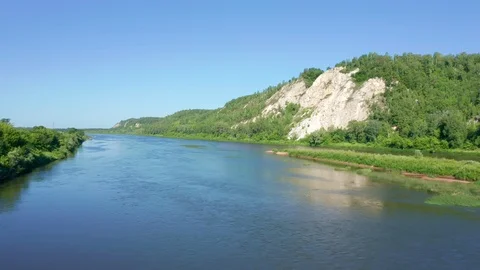 Flying on a river at the foot of a mountain range with white cliffs. Stock Footage 119075239