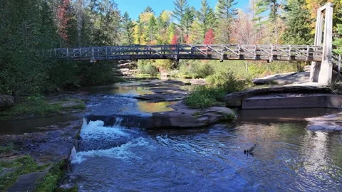 Flying A River, Under a Bridge, Above A Waterfall in Autumn Drone Shot Stock Footage 315265462