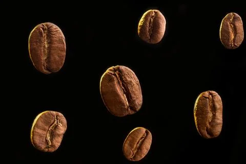Flying Roasted Coffee Beans on Black Background Stock Photos