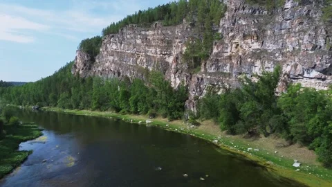 Flying to rocks over the small river in the wild nature Stock Footage 246581253
