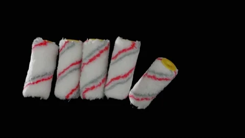 Flying rollers for paint on a black background. Super slow-motion. Видео 149177551