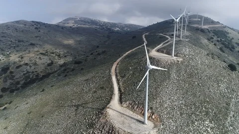Flying by rotating turbines of a wind power plant. Aerial shot, UHD Stock-Footage 103430204