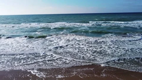 Flying to a sandy beach with beautiful waves on a blue sky background Stock Footage 238894576