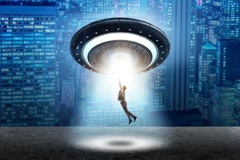 The flying saucer abducting young businessman Stock Photos