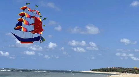 Flying ship, rainbow colored ship kite flies on the blue sky and cloud Stock Photos