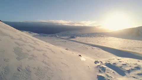Flying shot over a winter landscape, two cars driving along road by snow. 库存影片 88295898