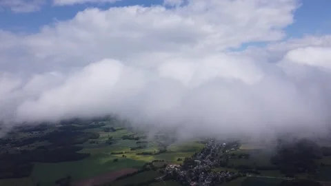Flying sidewards right in the middle of the Clouds, Village below, Aerial View. Stock-Footage 139315194